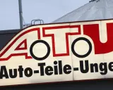 Leuchtreklame von A.T.U. Auto-Teile-Unger mit rotem Schriftzug und weißem Hintergrund.